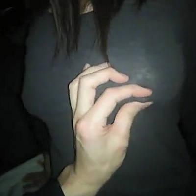 服の上から左乳首を摘ままれる女性